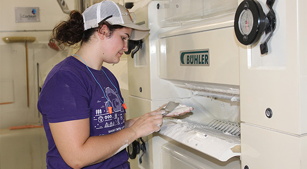 Rose looking at flour in a roller mill